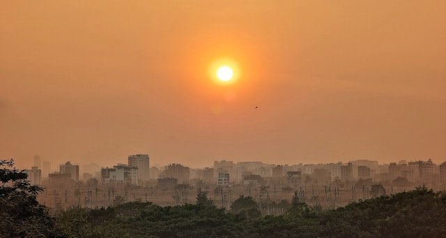 Dhaka skyline with a warm sunset glow.